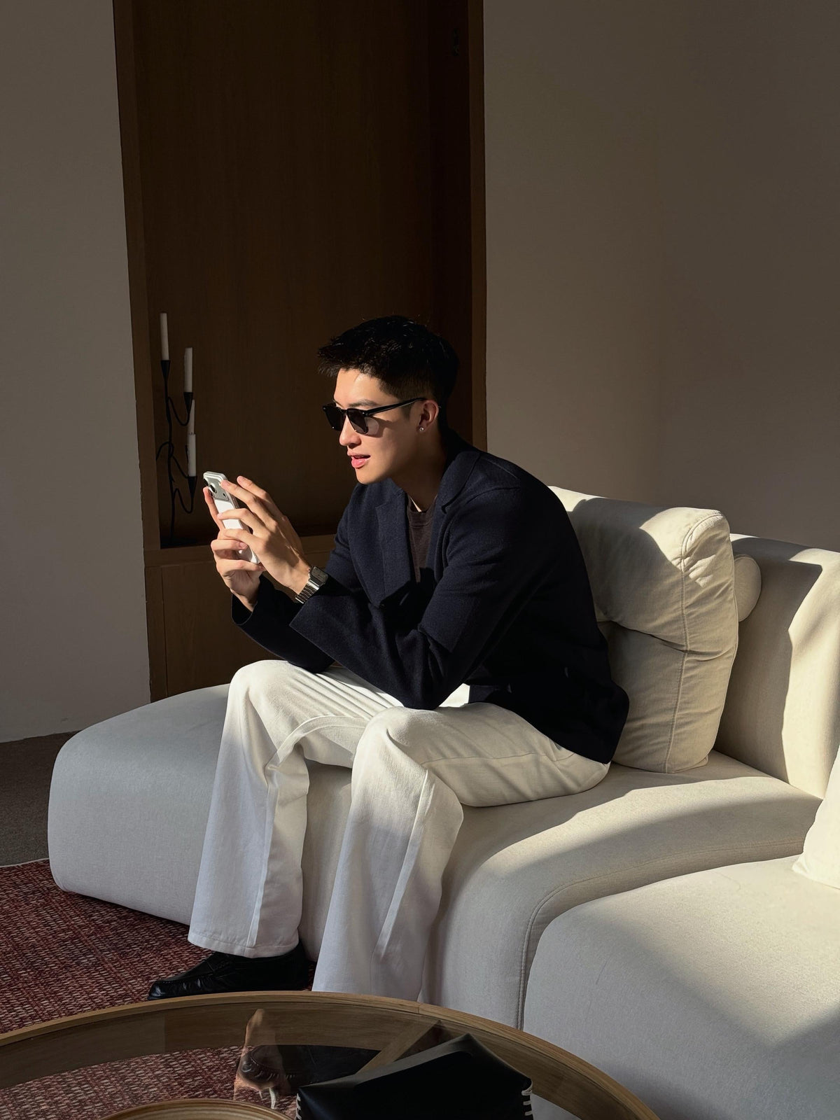 Man wearing a navy blazer with relaxed white trousers and black leather shoes