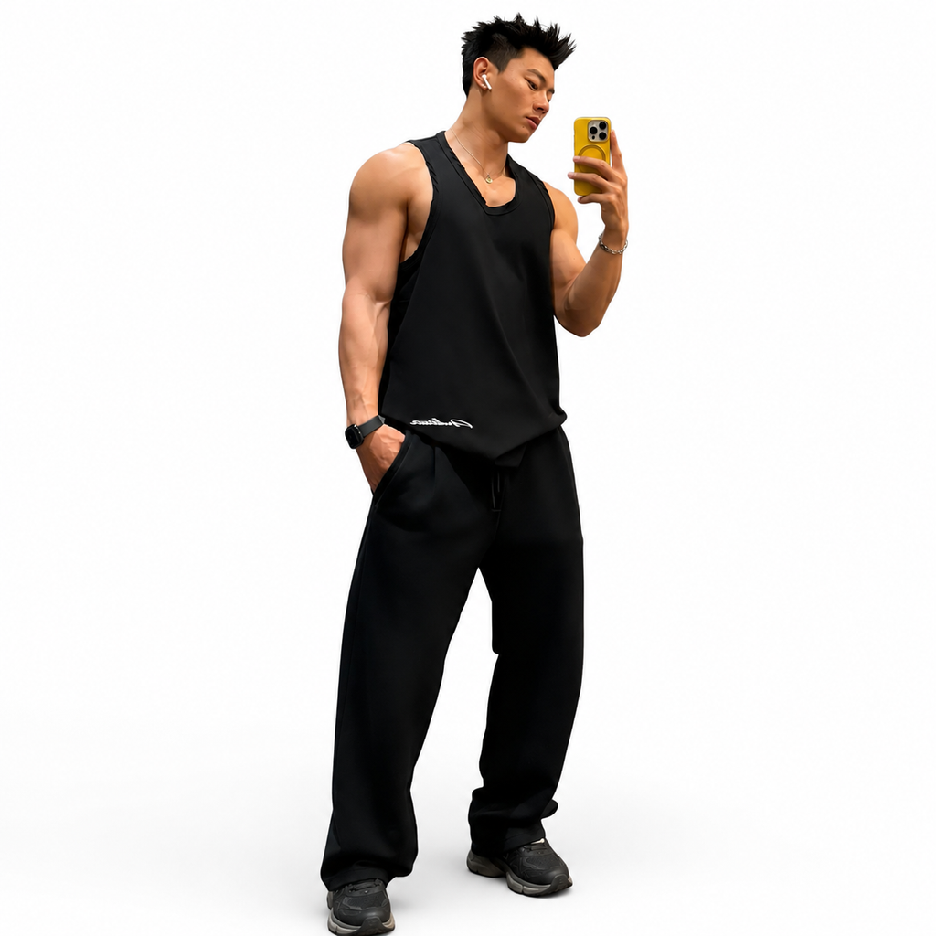Black men's distressed sleeveless tank top styled with loose training pants