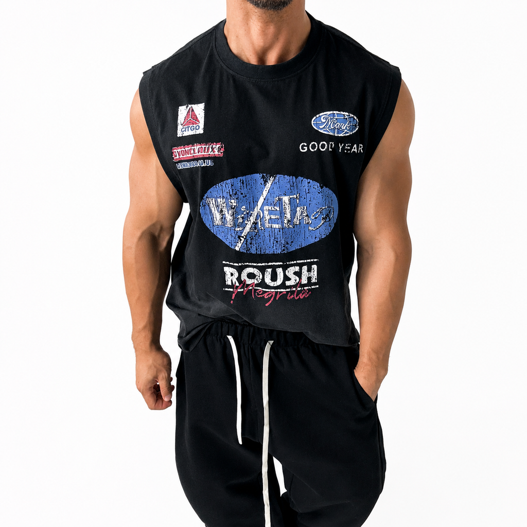 Men's black sleeveless graphic tank top worn with black casual pants.