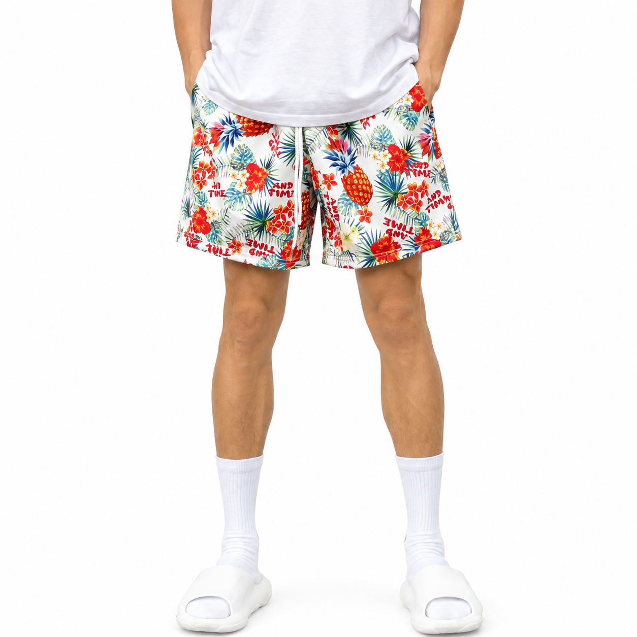 Varenform tropical print men’s training shorts worn with white T-shirt and slides