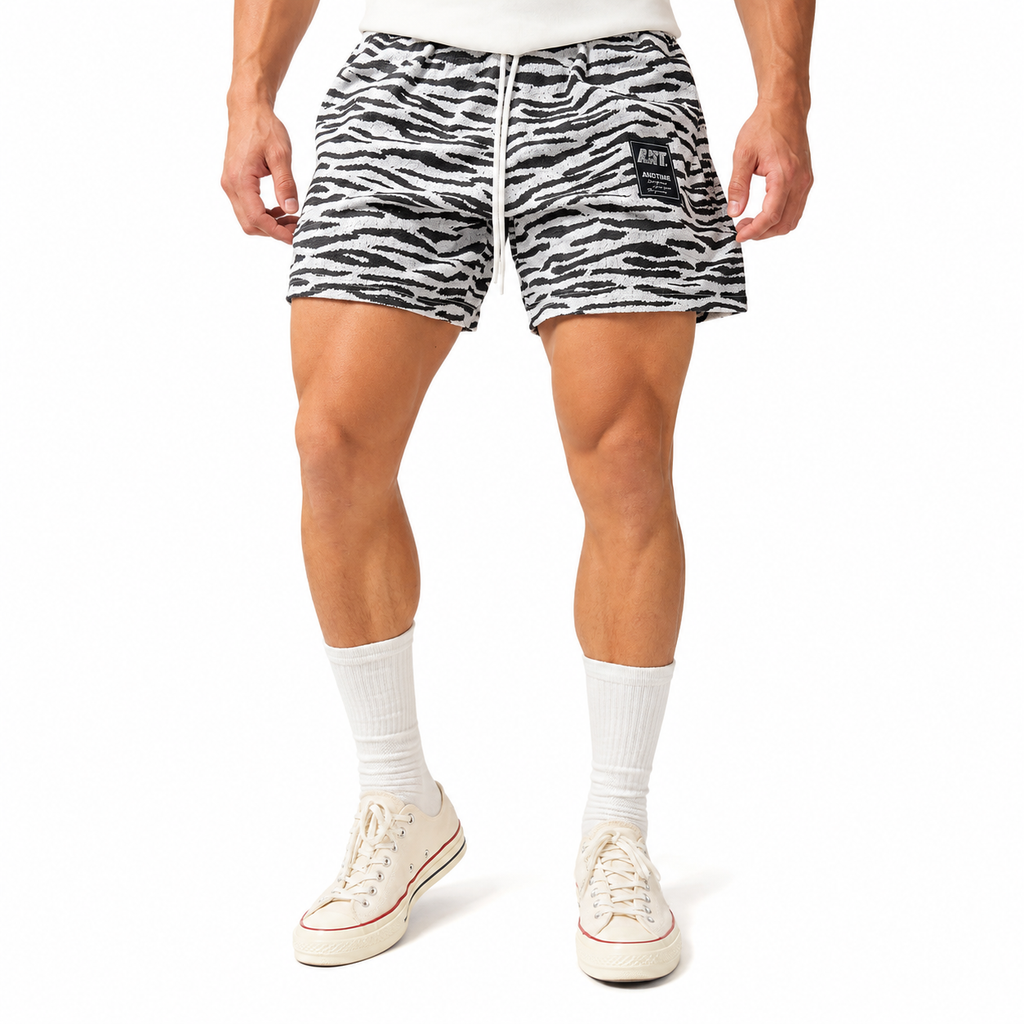 Men's zebra print athletic shorts worn with socks and sneakers, showing short athletic fit.