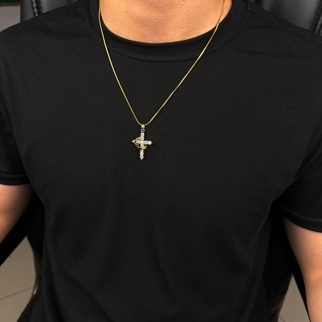Gold-tone cross pendant necklace shown worn on a black shirt